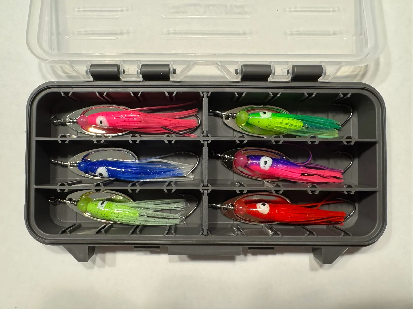SRT salmon spinner color set in an open tackle box — six powder-coated torpedo-body colors